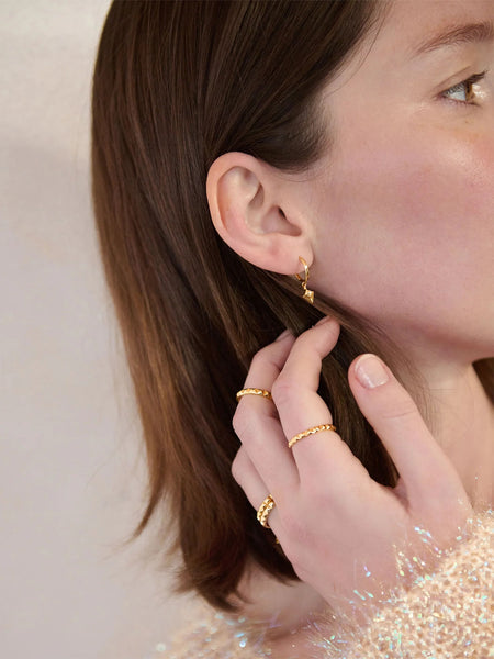 Gold Arrow Spike Huggie Earrings on model