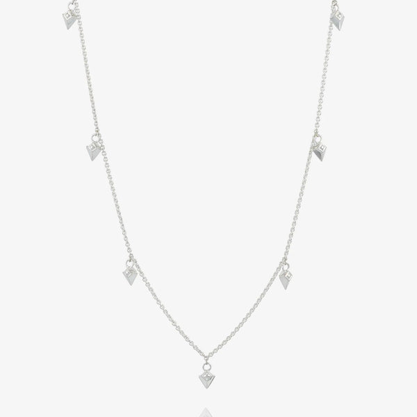 Silver necklace with arrow spike charms on light grey background