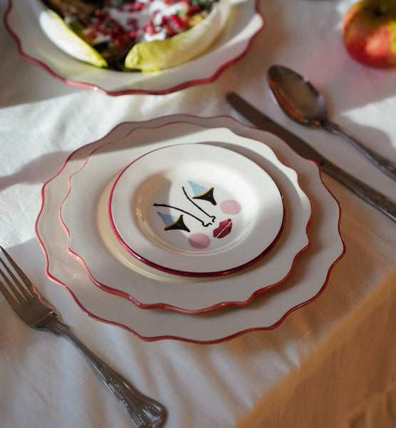Stack of ceramic plates with a scalloped edge. 
