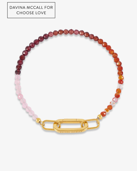 A beaded bracelet by Davina McCall featuring faceted beads that transition from pale pink to deep red and orange, secured with a large gold link clasp. The brand name 'Rachel Jackson' is engraved on the clasp, and a text overlay in the top left reads 'DAVINA MCCALL FOR CHOOSE LOVE'.