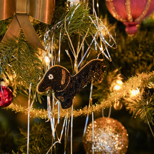 Decorative black  sausage dog ornament on a Christmas tree 