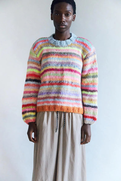 Person wearing a colorful  hand knitted striped sweater