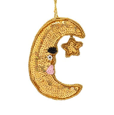 Sequined moon and star ornament on a white background