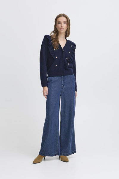 Woman wearing a navy blue cardigan with floral details.  