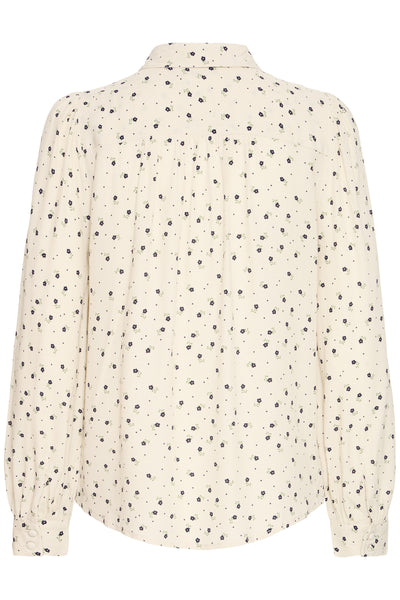 Back of cream blouse with black floral pattern on a white background