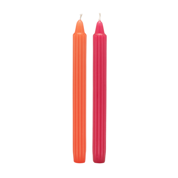 Two orange and pink candles on a white background
