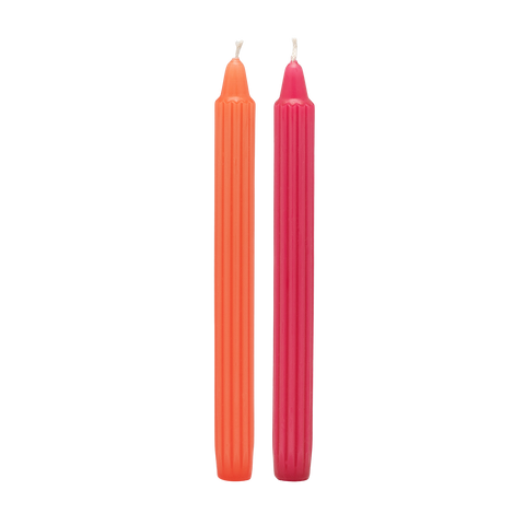 Two orange and pink candles on a white background
