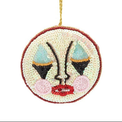 Embroidered ornament with a face design on a white background