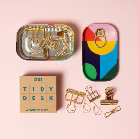 Colorful tin with assorted clips on a pink background