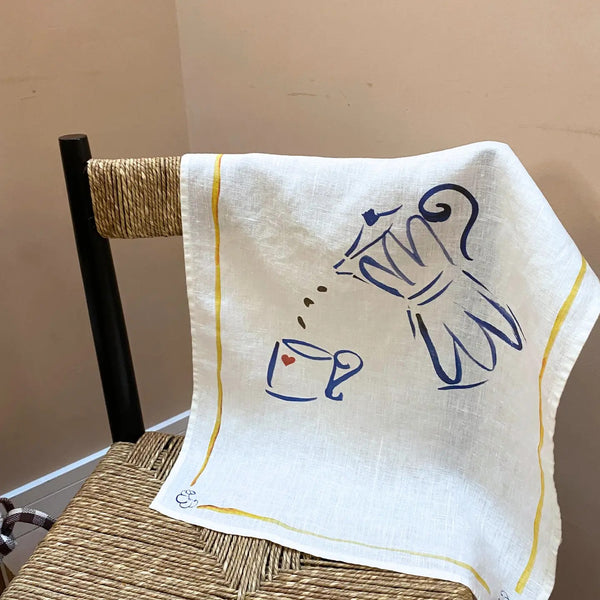White towel with blue coffee-themed design draped over a chair